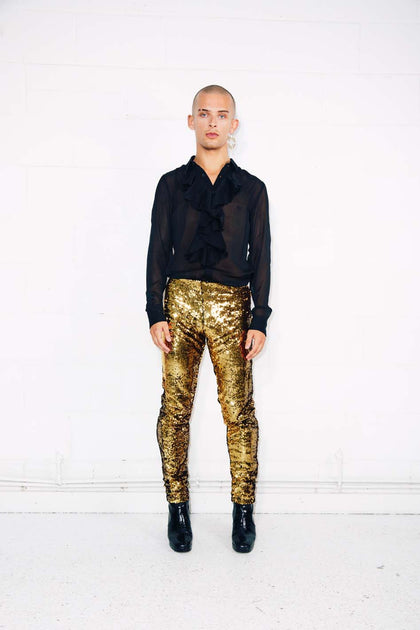 http://sparklebutt.co.uk/cdn/shop/files/Man-dancing-wearing-gold-sequin-pants-with-black-sheer-shirt-with-ruffle-and-mens-black-high-heeled-boots_1e10143f-4b09-45ac-af59-e7c8ce6f4eee_1200x630.jpg?v=1694496847