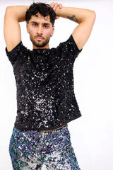 man wearing black sequin t-shirt and purple blue sequin shorts as part of a rave outfit for men
