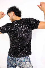 man wearing black sequin t-shirt and purple blue sequin shorts as part of a festival outfit for men