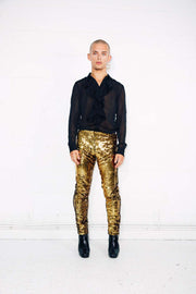 Man wearing gold sequin pants as part of a disco costume