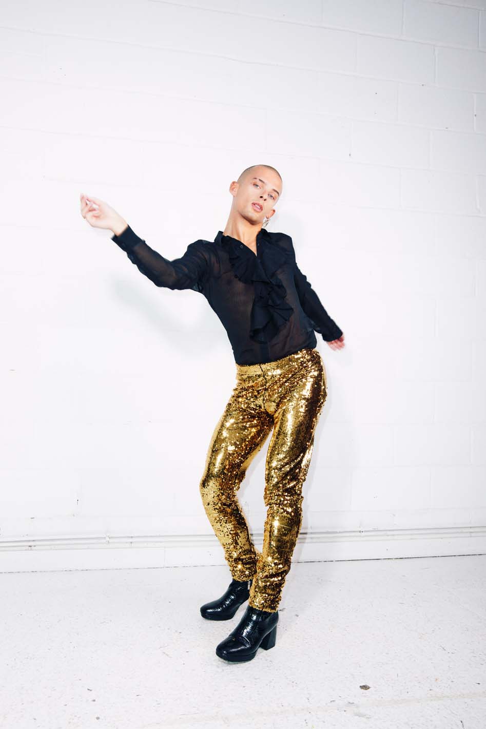 Man dancing in gold sequin pants as part of an elton john costume