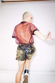 Man wearing rainbow gold sequin shorts