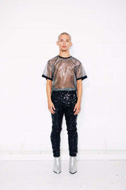 Man wearing black sequin pants with sheer silver t shirt as a mens party outfit