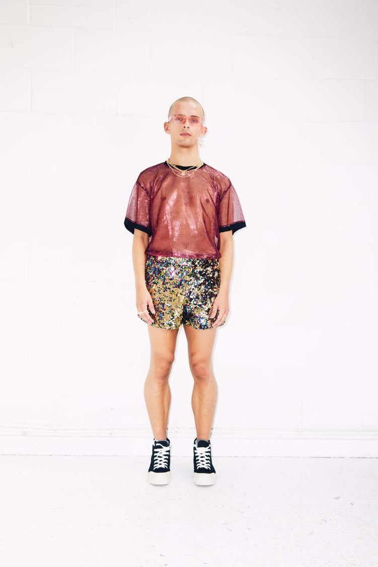 Man wearing rainbow gold sequin shorts