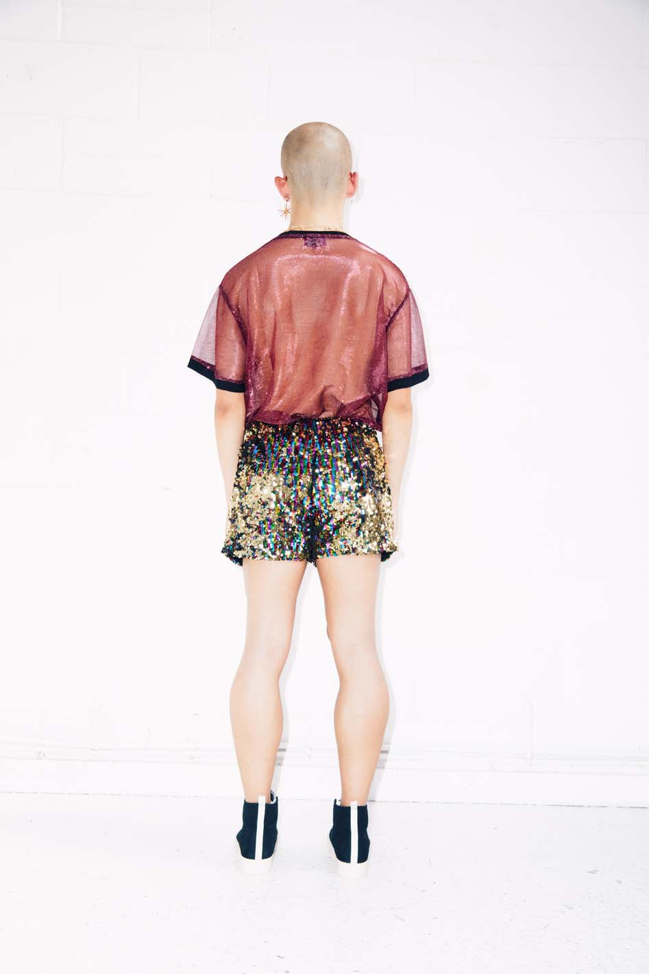 Man wearing rainbow gold sequin shorts