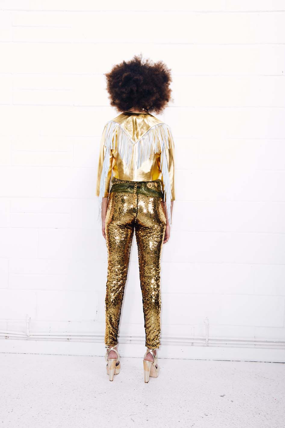 Woman wearing gold sequin pants as part of a studio 54 costume