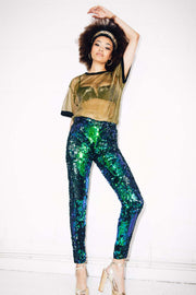 Woman wearing green sequin pants and terry de havilland shoes at party